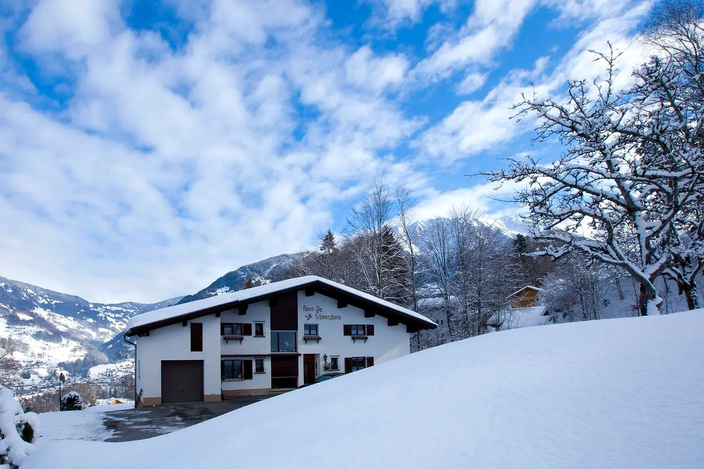Das Haus Schwarzhorn im Schnee, dahinter das Tal