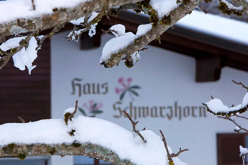Schriftzug „Haus Schwarzhorn“ an der verschneiten Fassade